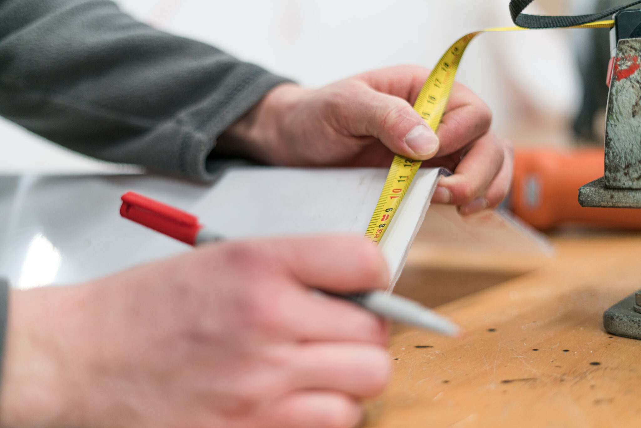 Jemand misst ein Metallstück ab.