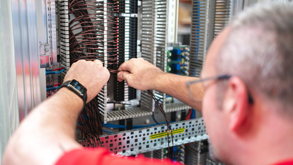 HSE Techniker schraubt am Schaltschrank