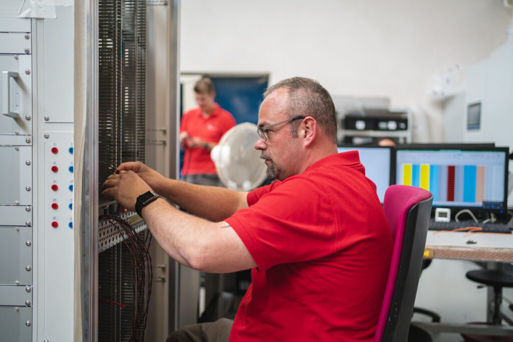 HSE Techniker schraubt am Schaltschrank
