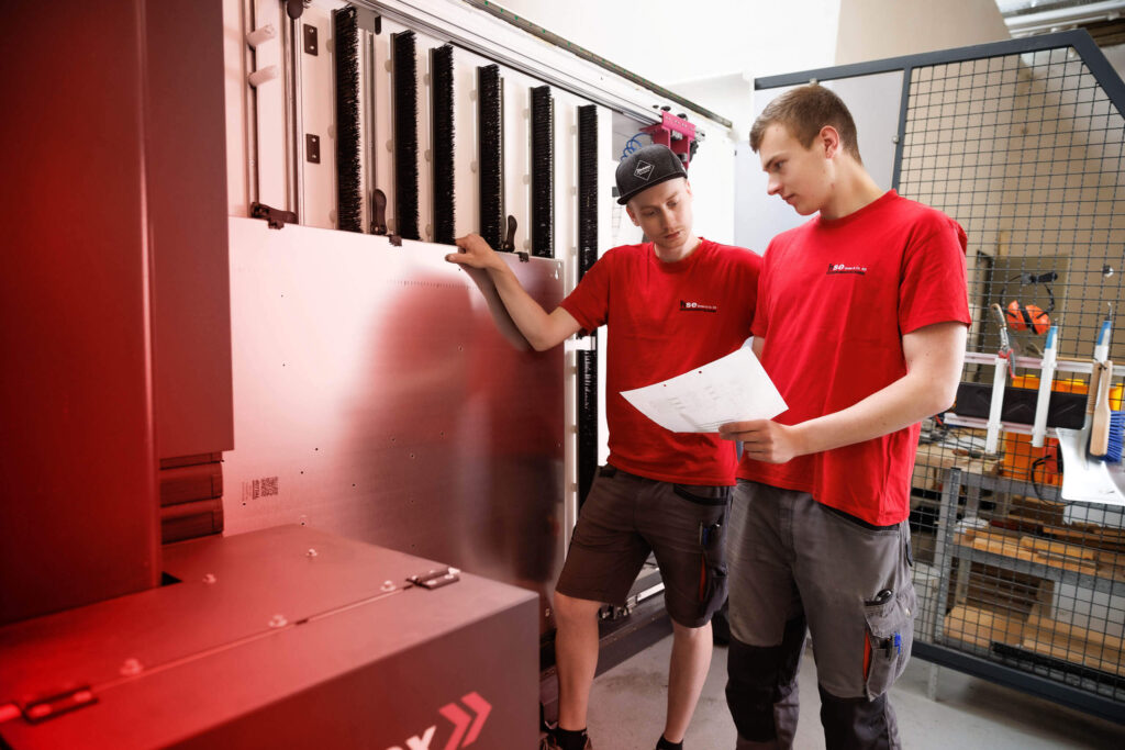 Zwei hse-Mitarbeiter schauen gemeinsam auf einen Schaltplan auf Papier