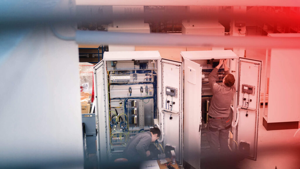 Zwei hse Techniker arbeiten an einem Schaltschrank.